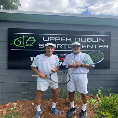 Marshall J. Hubsher holding the Men's 70 Tennis Tournament trophy at Upper Dublin, celebrating his victory